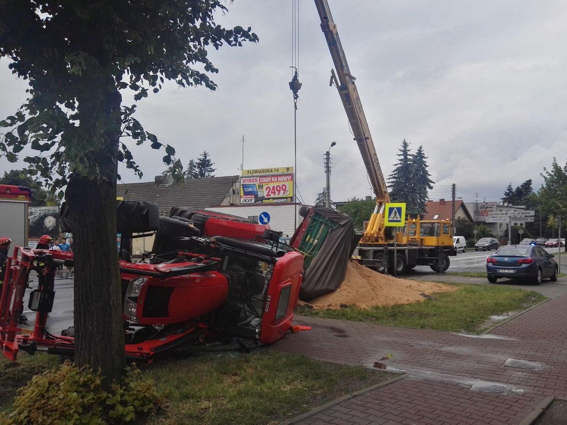 Ciągnik z trocinami przewrócił się na drodze ZDJĘCIA